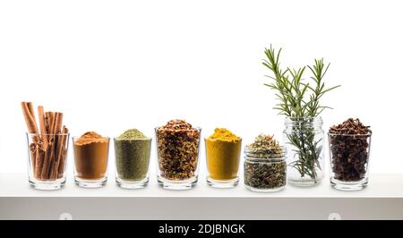 glass jars with various spices on white shelf Stock Photo