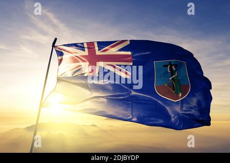 Montserrat flag waving on the top sunrise mist fog Stock Photo