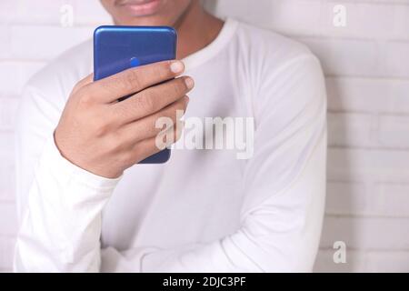 young man in casual dress using smart phone. Stock Photo