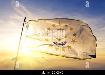 Rhode Island state of United States flag waving on the top sunrise mist fog Stock Photo