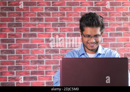 happy young asian man working on laptop with copy space  Stock Photo