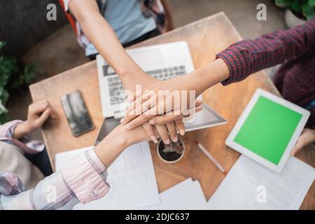 Close up of hands young asian students meeting in a cafe doing high five together Stock Photo