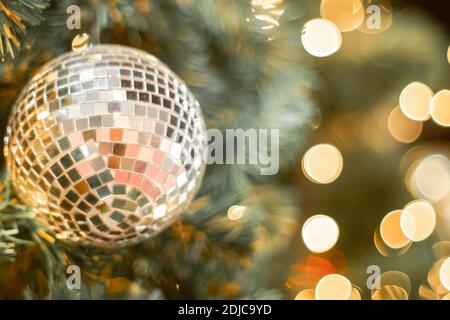 Selective focus Christmas tree with holiday silver disco balls and lights with copy space on blurred bokeh background. Stock Photo