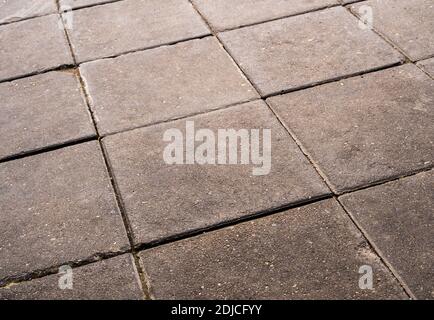 The road side pathway is paved with square blocks of concrete Stock Photo
