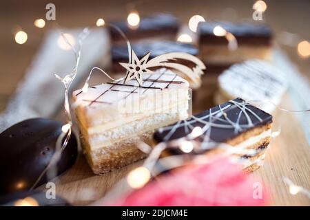 Selection of colorful and delicious cake desserts on rusty wooden table. Stock Photo