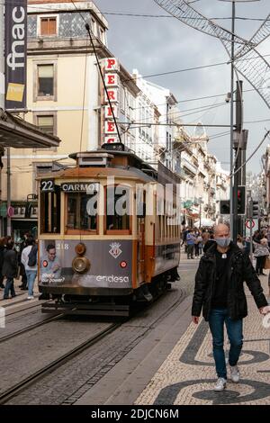 A Vintage Tram on a Crowded Street with People Wearing Covid-19 Masks during Christmas Shopping - Porto, Portugal Stock Photo