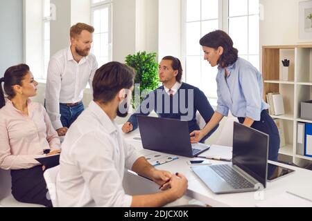 Successful group of diverse businessmen discussing together a project around a desk in the office. Stock Photo