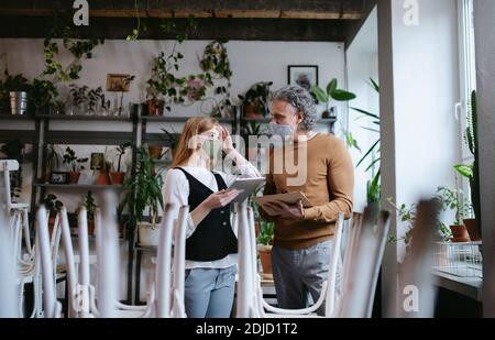 Man and woman managers in closed cafe, small business lockdown due to coronavirus. Stock Photo