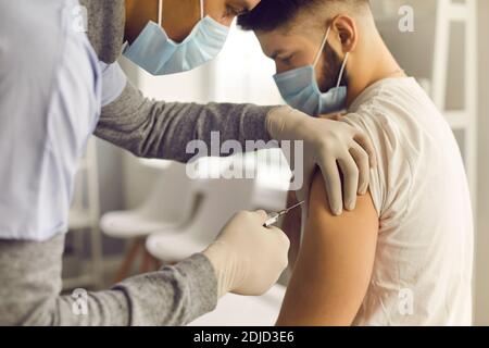 Doctor injecting patient with antiviral vaccine during mass vaccination campaign Stock Photo