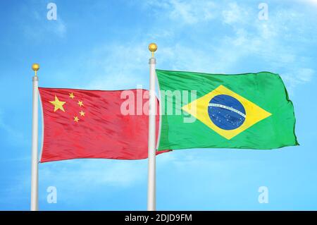 China and Brazil two flags on flagpoles and blue cloudy sky Stock Photo