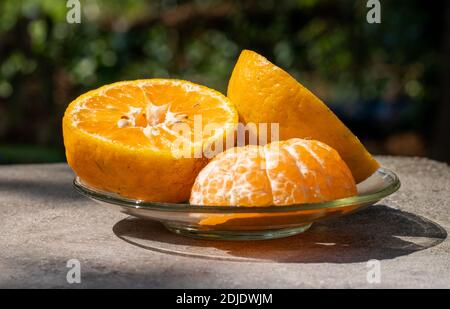 three pieces of orange half cut, in a plate Stock Photo