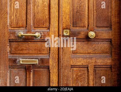 Gold metal brass details handle on old wooden door. Handle, keyhole letter hole different French style door handles. Brown old wooden shabby vintage Stock Photo