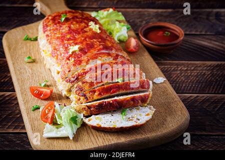 Tasty homemade ground baked turkey meatloaf with corn and slices pumpkin on wooden table. Food american meat loaf. Stock Photo