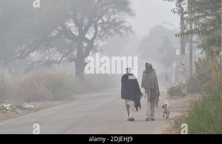 Jammu, Indian-controlled Kashmir. 14th Dec, 2020. People walk through a dense fog on the outskirts of Jammu, the winter capital of Indian-controlled Kashmir, Dec. 14, 2020. Credit: Str/Xinhua/Alamy Live News Stock Photo