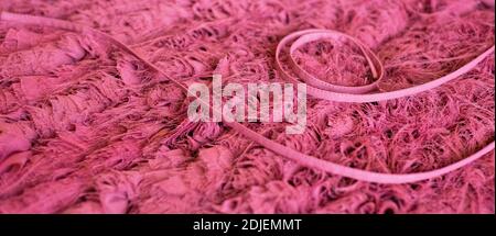 Pink background from chiffon texture and curly cord. Crappy texture and thread pattern. Stock Photo