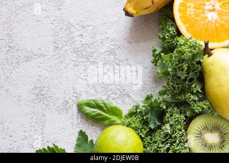 Green vegetables and fruits on concrete background, ingredients for smoothie Stock Photo