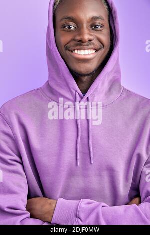 funny dark skinned male model in purple pullover posing at camera isolated in studio, smiling Stock Photo