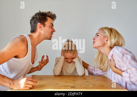 daughter is tired of family conflicts,divorce and children concept. little kid girl is upset with quarrelling of parents, they are going to be divorce Stock Photo