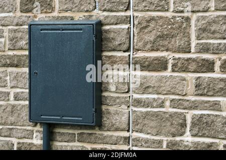 Plastic box for electricity and gas meters on the side of a new house. No people. Stock Photo