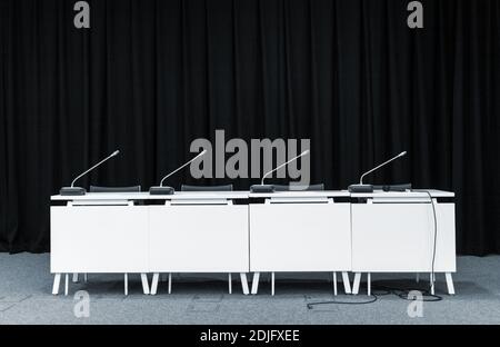Monochrome picture of conference stand table with microphones in a meeting room Stock Photo