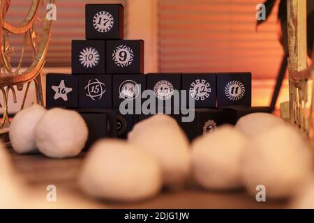 A Christmas calendar made out of black cubes in back of white white snowballs Stock Photo