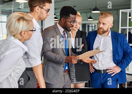 side view on confident afro american leader of team talking with employees, asking to hurry up for deadline Stock Photo