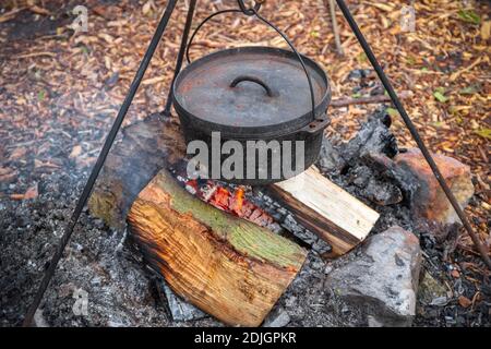 Cooking food in a cauldron over campfire in England Stock Photo