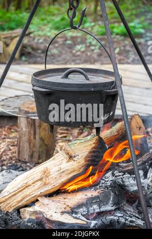 Cooking food in a cauldron over campfire in England Stock Photo