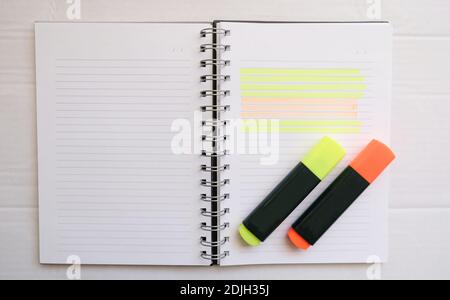 orange and yellow hihglighter on the empty lined notebook. preparation of make a homework.Business work area concept. Stock Photo