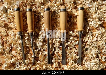 hobby toll chisels on the carpenter's workbench, chisel in the yellow waad sawdust, chisel on the presentation board, wood hobby tools Stock Photo