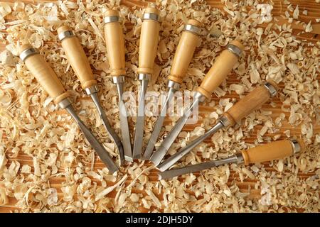 hobby toll chisels on the carpenter's workbench, chisel in the yellow waad sawdust, chisel on the presentation board, wood hobby tools Stock Photo