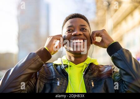 Young man wearing headphones and listening to music in the city Stock Photo