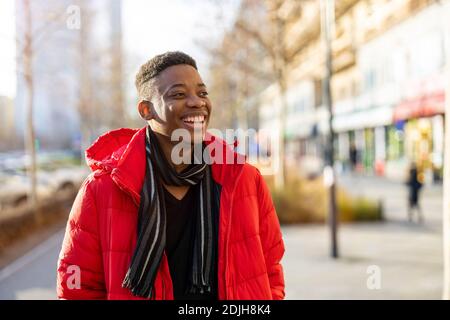 Portrait of a young man standing in a city street, smiling Stock Photo