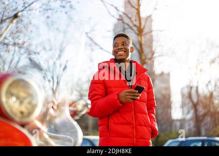 Portrait of a young man standing in a city street, smiling Stock Photo