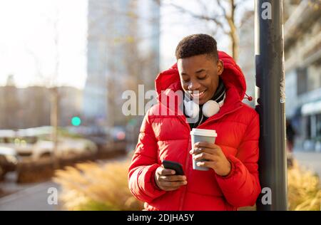 Young man using smart phone outdoors at urban setting Stock Photo