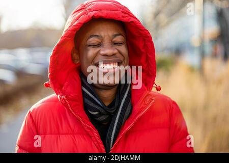 Laughing young man wearing a hood outdoors Stock Photo