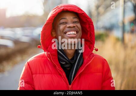 Laughing young man wearing a hood outdoors Stock Photo