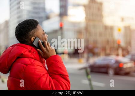 Young man using smart phone outdoors at urban setting Stock Photo