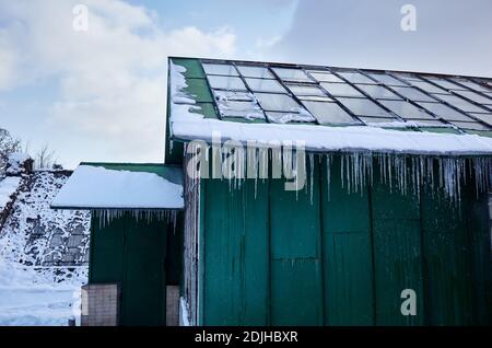 Icicles in winter. Ice stalactite hanging from the glass roof of building Stock Photo