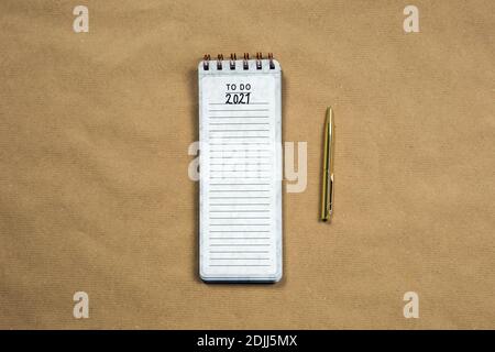 Planning New Year goald on empty notepad in the year 2021, top view on brown background texture, top view copy space, space for text modern design Stock Photo