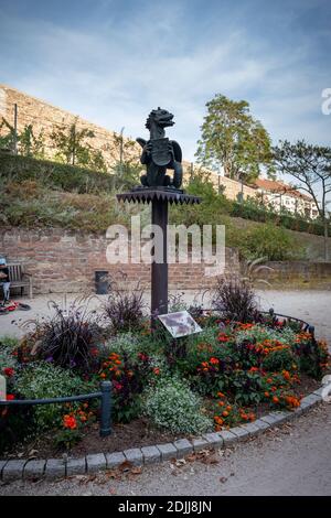 Dragon statue in a flower garden in Worms, Germany on a summer day. Stock Photo