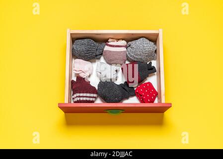 Top view with wooden drawer with socks on a yellow background. Variety of socks in a drawer isolated on colored background. Stock Photo