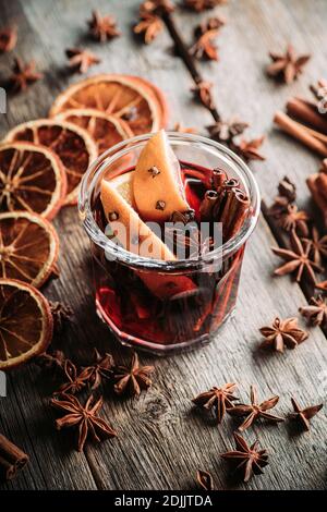 Mulled red wine with oranges and different spices in glass on the rustic background. Christmas food. Winter decorations. Selective focus. Shallow dept Stock Photo