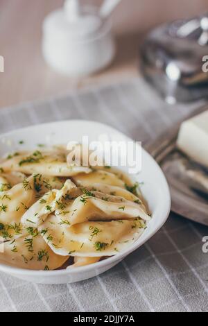 Dumplings, filled with meat and served with fried onion and meat pieces. Varenyky, vareniki, pierogi, pyrohy. Dumplings with filling. Stock Photo
