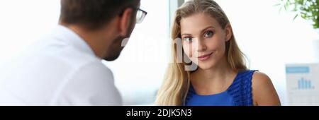 Charming young woman working with colleague in office Stock Photo