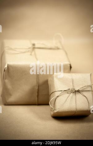 two gift package wrapped with plain brown paper and rope and brown paper background texture, retro gift box. present concept Stock Photo