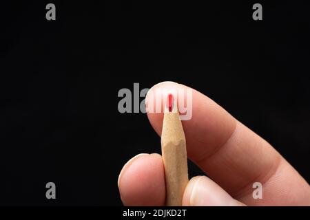 Hand holding a red colored pencil Stock Photo