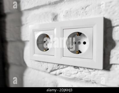 Plastic German double socket-outlets type F with grounding. Pair of empty, unplugged, european white power sockets or electrical outlets CEE 7 with Stock Photo
