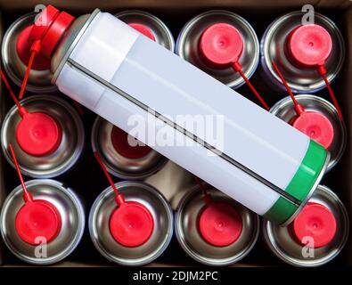 spray can on multiple cans in a box with caps on the spray at shallow depth of field Stock Photo