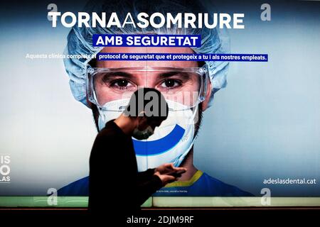 Man walking past an ad whilst looking at his smartphone, Barcelona. Stock Photo